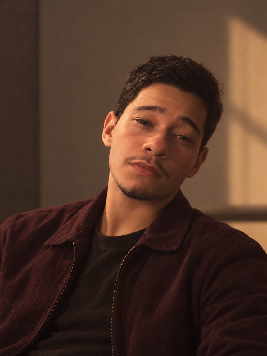 Retrato de Guilherme Dos Santos com jaqueta vinho e iluminação quente